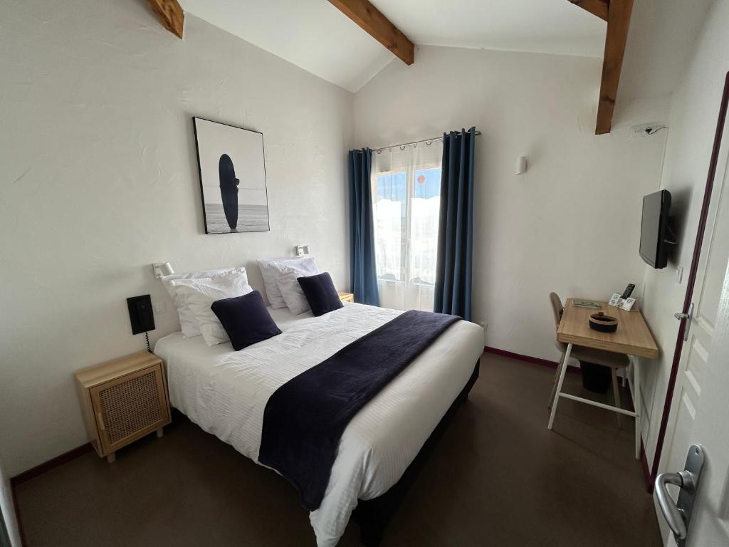 a bedroom with a large bed and a window at Logis Hotel De La Clape in Narbonne-Plage