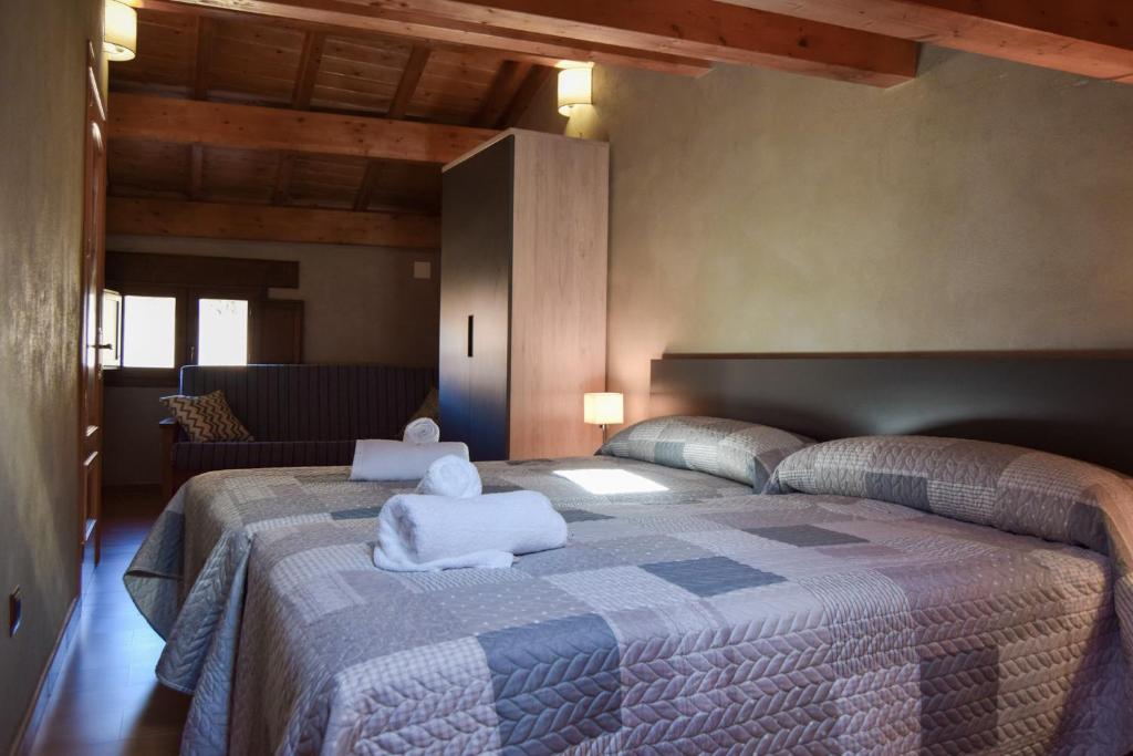 um quarto com uma cama grande e toalhas em Casa Rural Martín em Tronchón