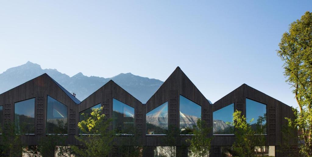 een weergave van een gebouw met bergen op de achtergrond bij quartier - über Nacht in besonderer Architektur in Garmisch-Partenkirchen