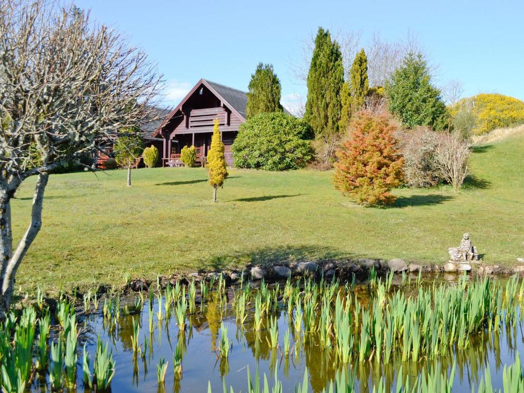 a house with a pond in front of it at Chalet 2 in Torcastle