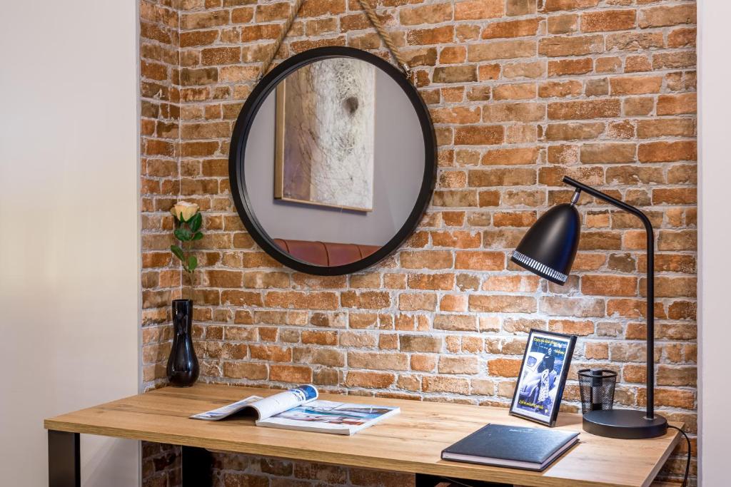 a mirror on a brick wall next to a table at Sylvia suite@Kantrida in Rijeka