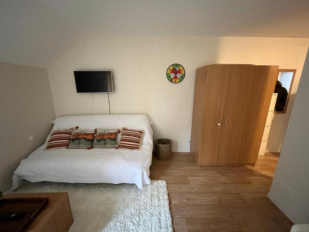 a bedroom with a bed and a cabinet with a television at La Poudreuse Résidence les Balcons d'Aix in La Féclaz