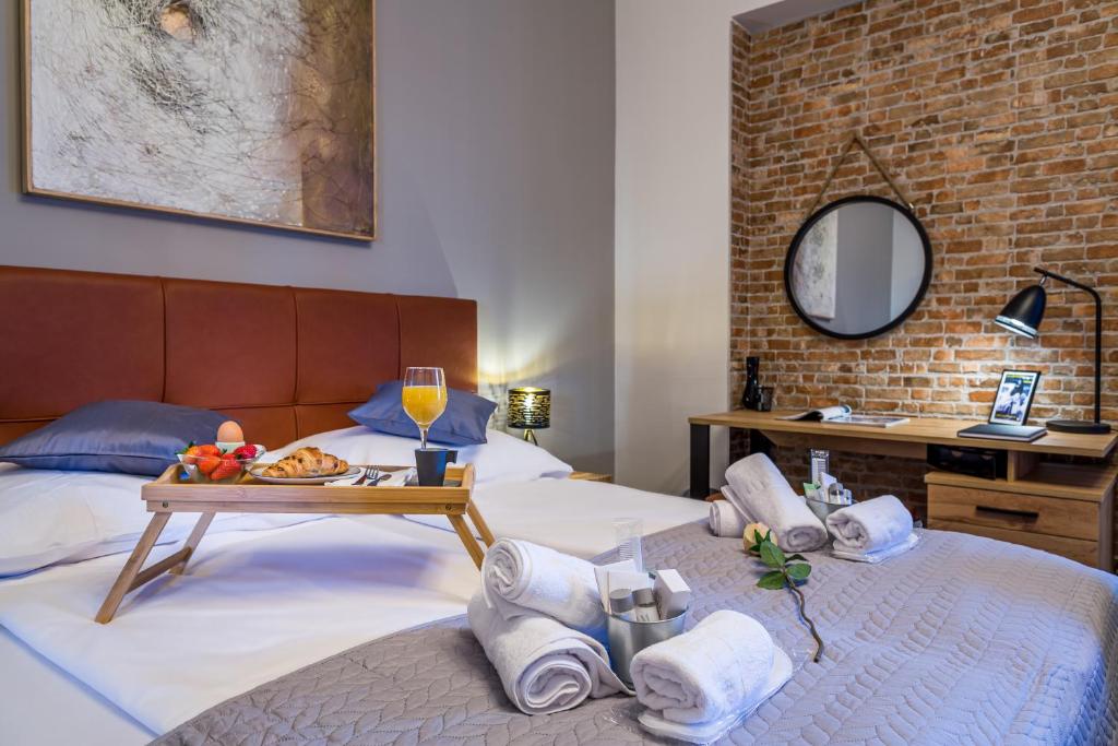 a hotel room with two beds with towels and a tray of food at Sylvia suite@Kantrida in Rijeka