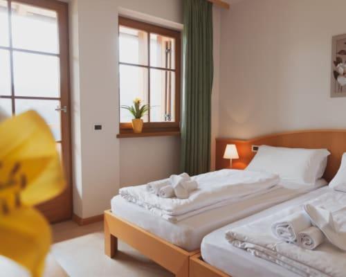 a bedroom with two beds and a window at Hotel Corno Bianco in Nova Ponente
