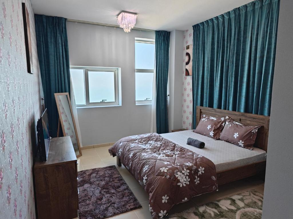 a bedroom with a bed with green drapes at Diamond Room in Shared Apartment in Ajman 