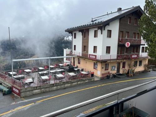 ein Gebäude, in dem Autos an der Straßenseite geparkt sind in der Unterkunft Hotel Restaurant Emshorn in Oberems