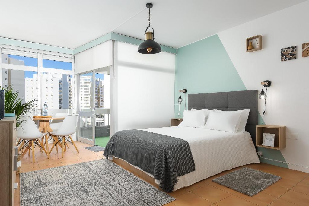 1 dormitorio con 1 cama, mesa y sillas en Cantinho do Mar, en Portimão