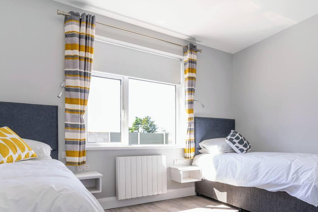 1 dormitorio con 2 camas y ventana en Burrows Lodge en Waterford