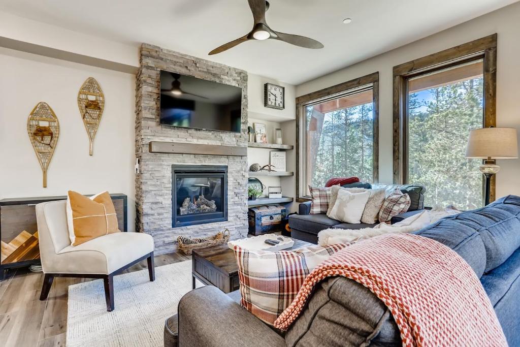 a living room with a blue couch and a fireplace at Seasons 1825 in Keystone