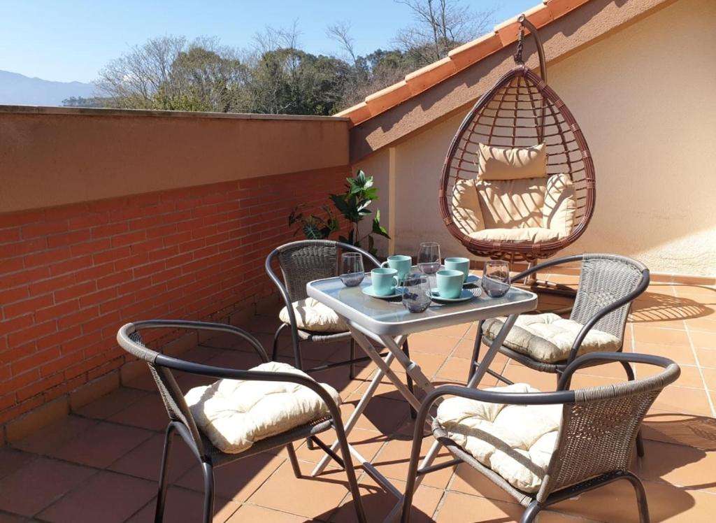a patio with chairs and a table and a swing at Casa vacacional Mirador de San Vicente in Serdió
