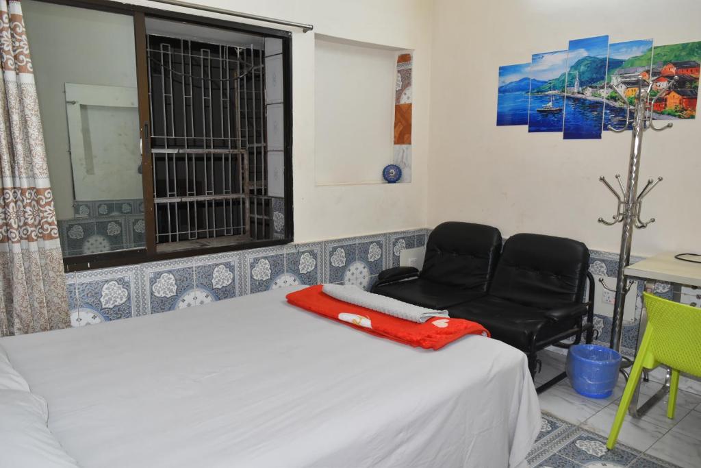 um quarto com uma cama, uma cadeira e uma janela em Homestay 3 em Daca