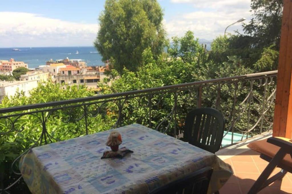a table on a balcony with a view of the ocean at Appartamento in villa vista mare in Ischia