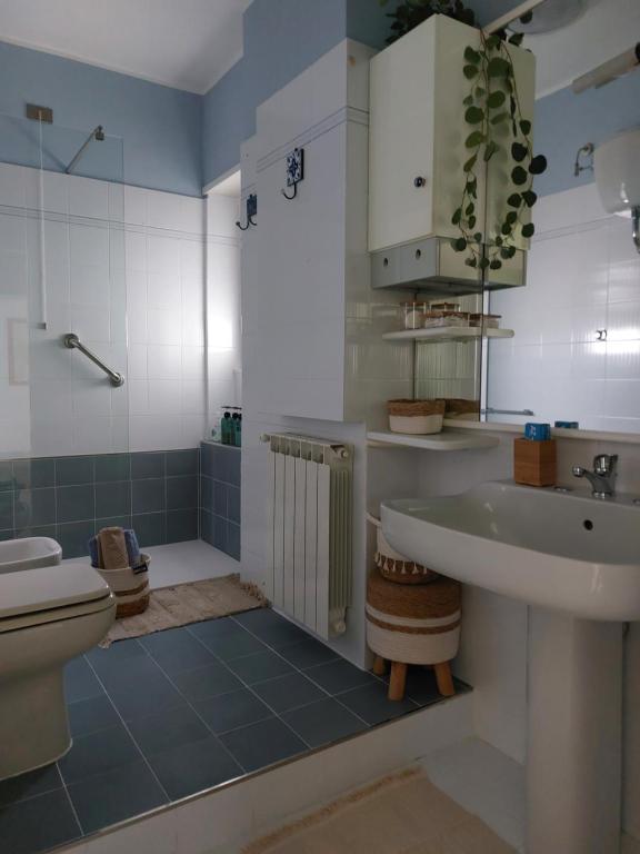 uma casa de banho com um lavatório e um WC em Appartamento CasaZeta luminoso e centralissimo em Latina