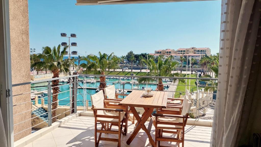 a table and chairs on a balcony with a view of the pool at Mare Marina View 1 in Xylokastron