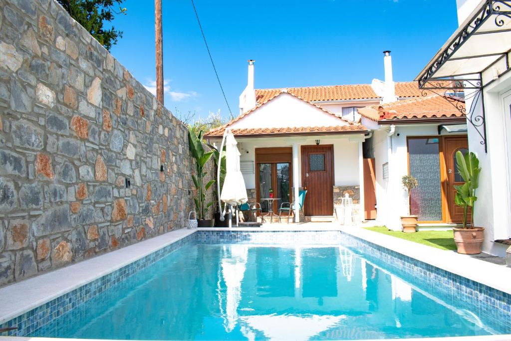 a swimming pool in front of a house at Del Sol Suites in Skiathos