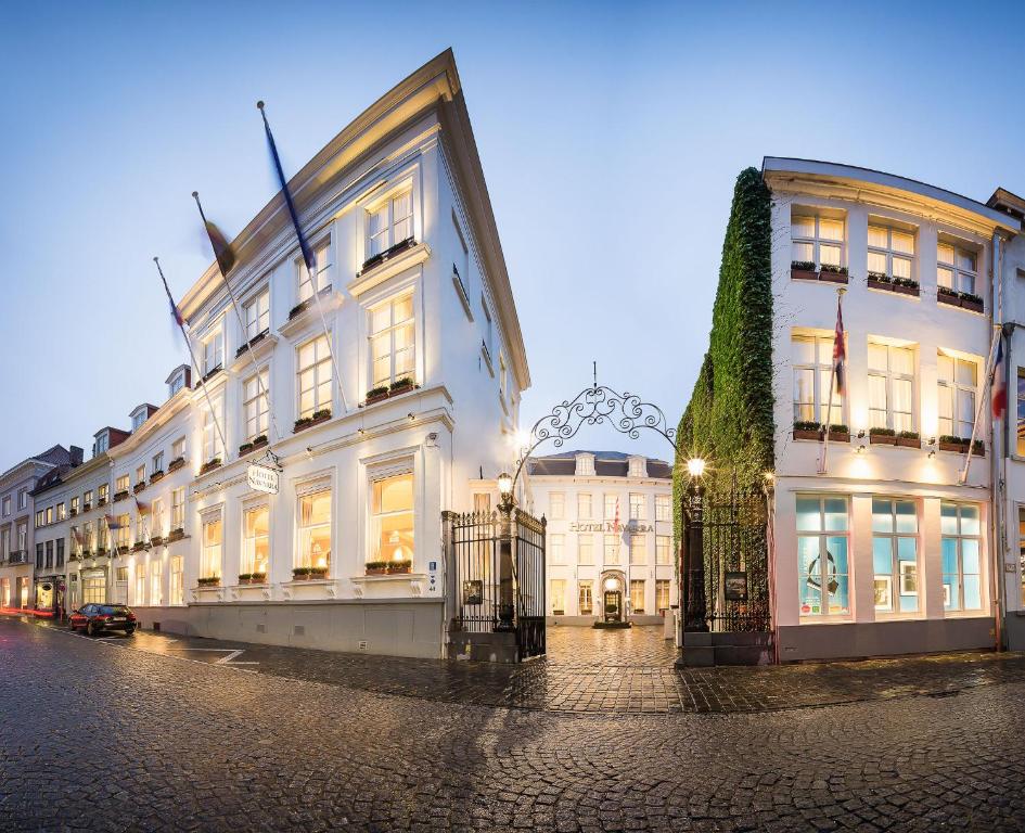 een groot wit gebouw aan de straatkant bij Hotel Navarra Brugge in Brugge