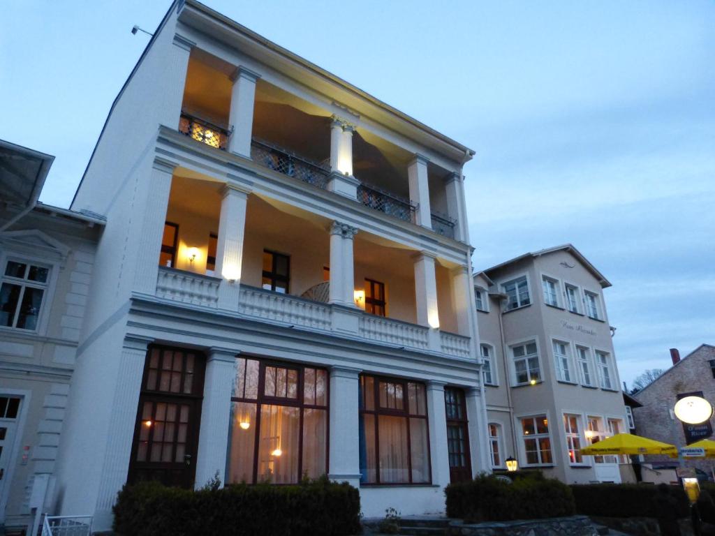duży biały budynek z kolumnami i oknami w obiekcie Haus Alexander w mieście Heringsdorf