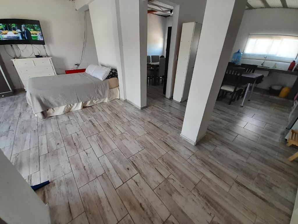 Habitación con cama y suelo de madera. en Alquiler temporario villa allende en Córdoba