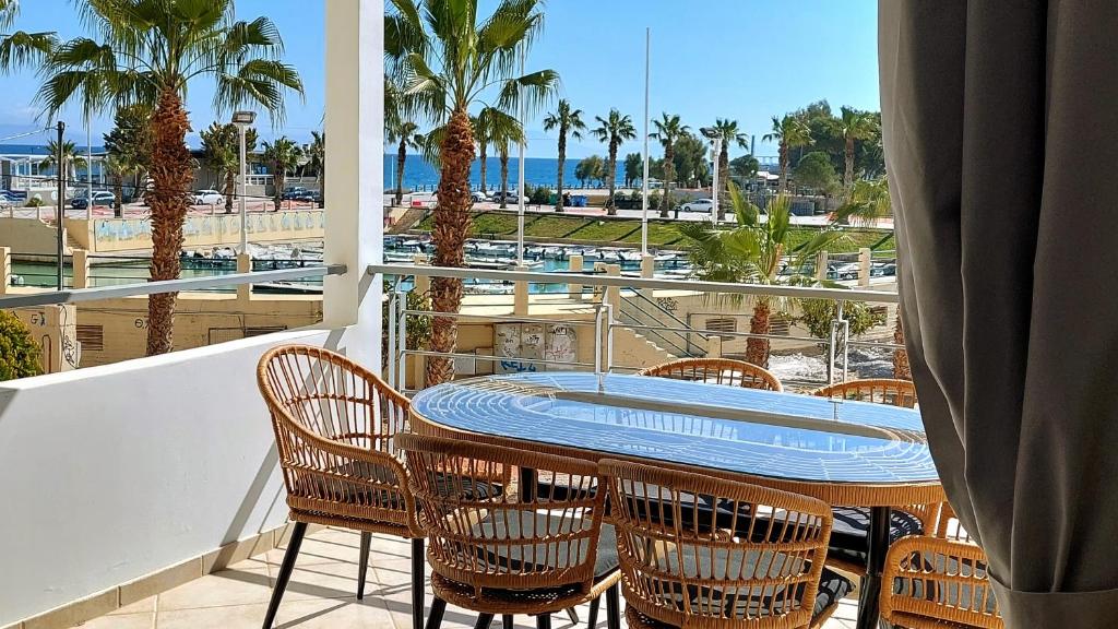 a balcony with a table and chairs and a view of the ocean at Mare Marina View 2 in Xylokastro