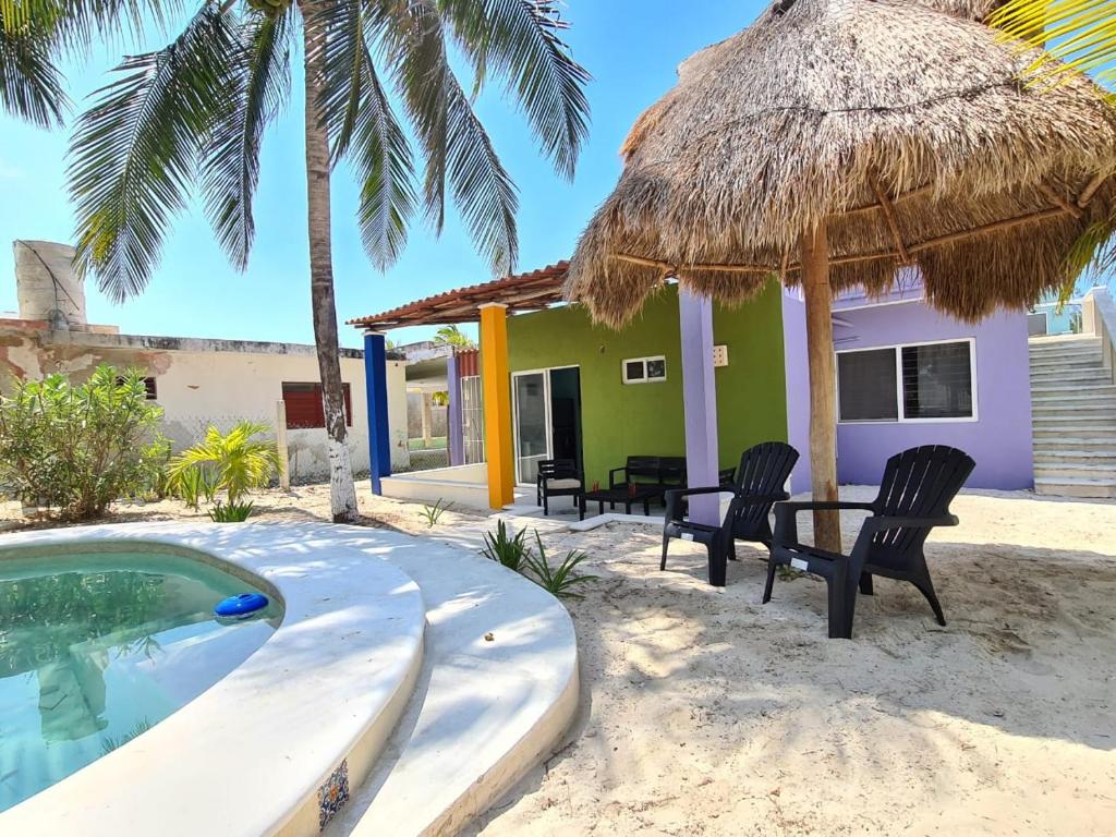 un complejo con piscina, sillas y una casa en Palapa rooftop w/ beach views! Cozy Casa Dumas, en Chuburná