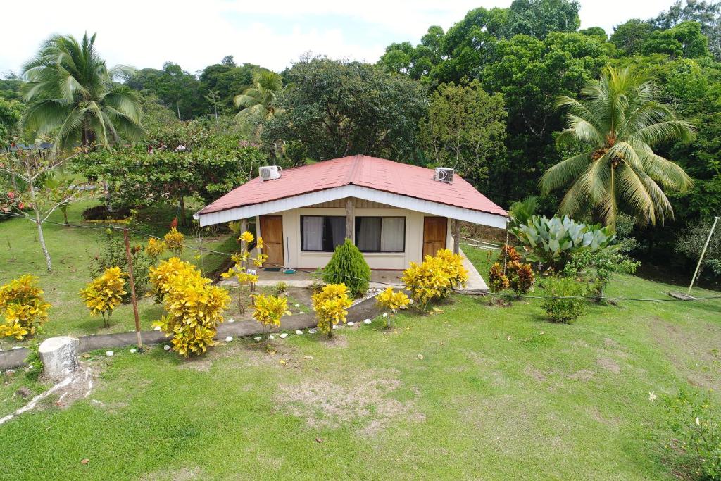 a small house with a pink roof in a yard at Hope Garden in Sarapiquí