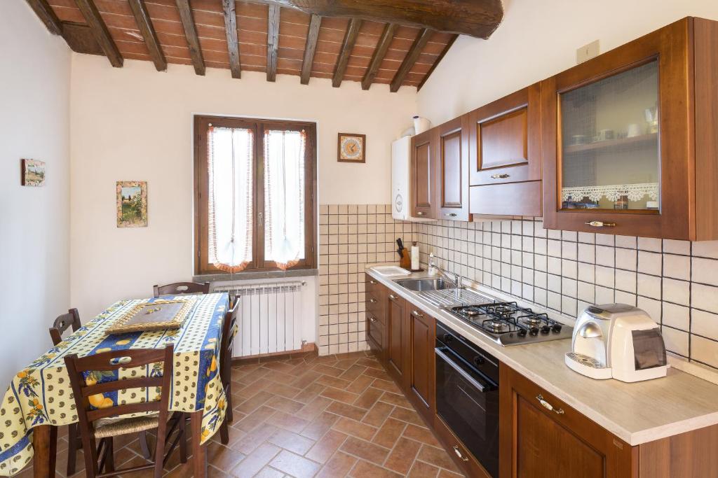 a kitchen with wooden cabinets and a stove top oven at Casa Galina in Ciggiano