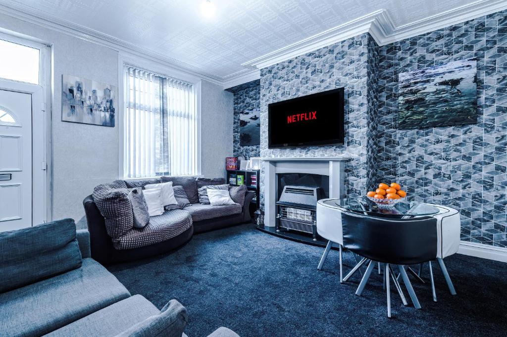 a living room with a couch and a tv at Stunning three Bed House in Bradford in Bradford