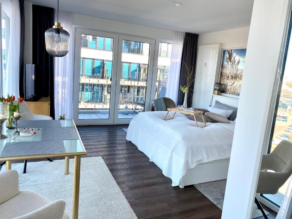 Helles Apartment über den Dächern Rostocks في روستوك: غرفة نوم مع سرير وغرفة معيشة