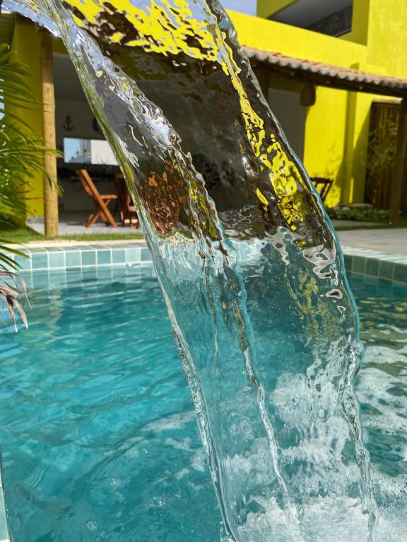 uma fonte de água numa piscina em Villa Suites Gostoso - Condomínio Beira-mar em São Miguel do Gostoso