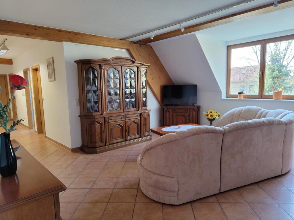 a living room with a couch and a wooden cabinet at Ferienwohnung Hohenroda in Hohenroda