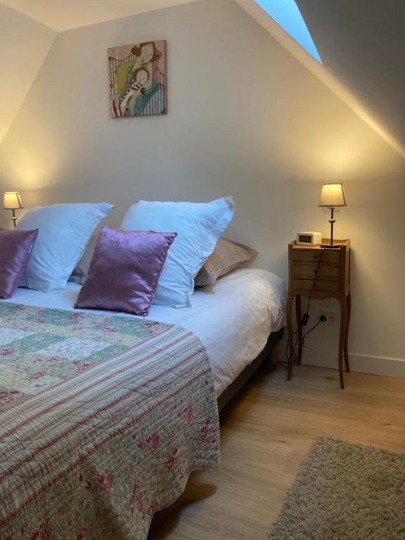 シュノンソーにあるLe Loft - Chenonceaux - 3 étoilesのベッドルーム1室(紫色の枕が付くベッド1台、ナイトスタンド付)