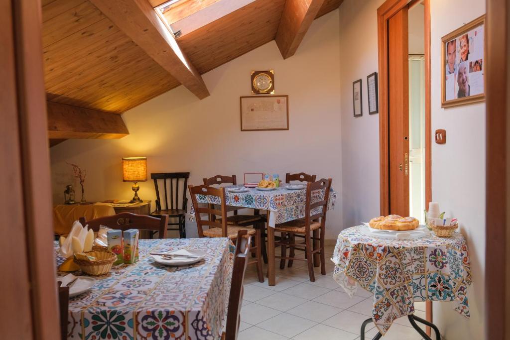 een eetkamer met tafels en stoelen en een klok bij B&B Sogni Goti in SantʼAgata deʼ Goti