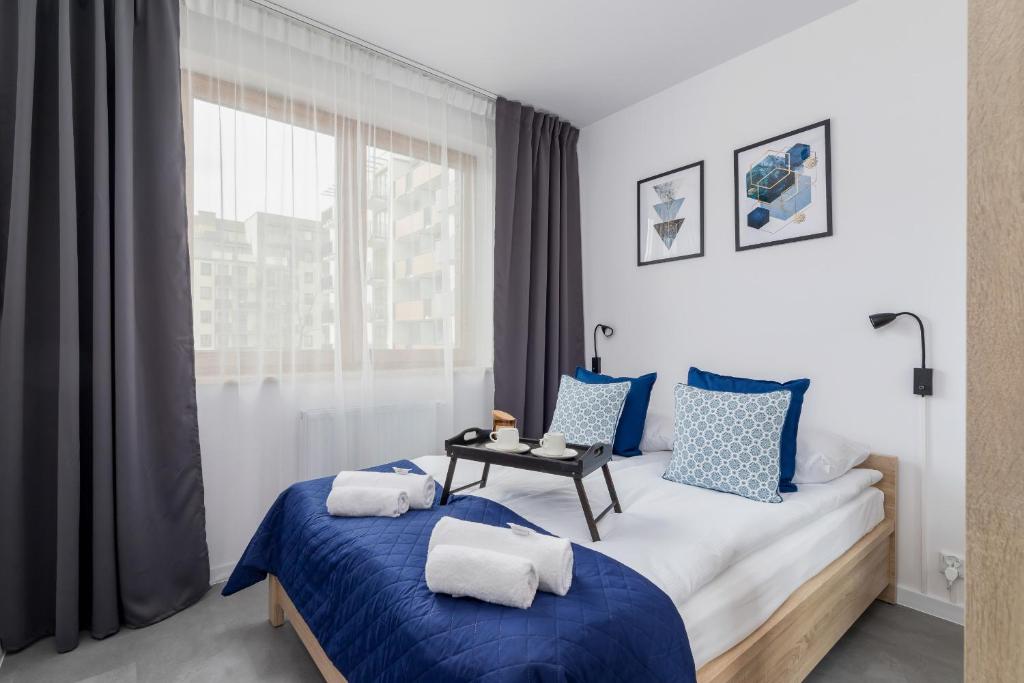 1 Schlafzimmer mit 2 Betten und einem Fenster in der Unterkunft Lux Apartment Grzegórzecka Estate Cracow by Renters Prestige in Krakau