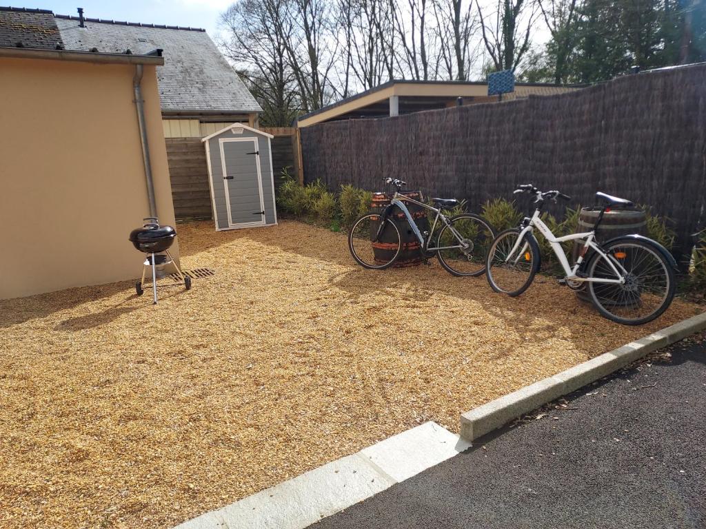 two bikes parked in a yard next to a fence at La Clé du Chesnot in Saint-Quentin-sur-le-Homme