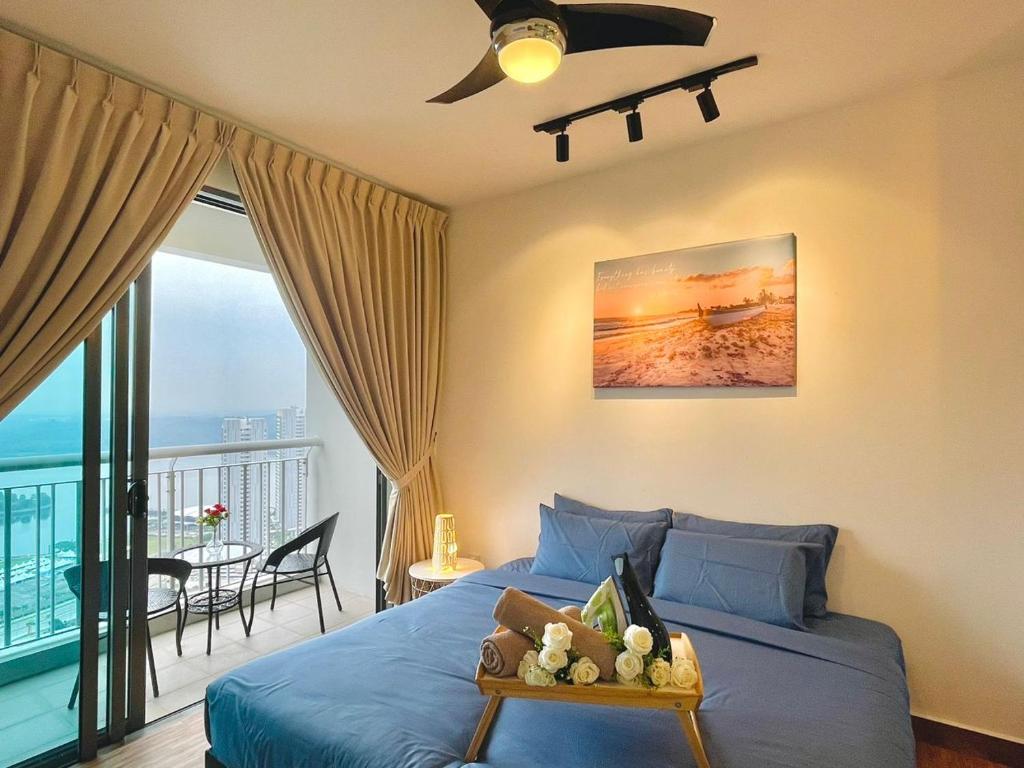 um quarto com uma cama azul e uma varanda em Teega Suites by Antlerzone em Nusajaya
