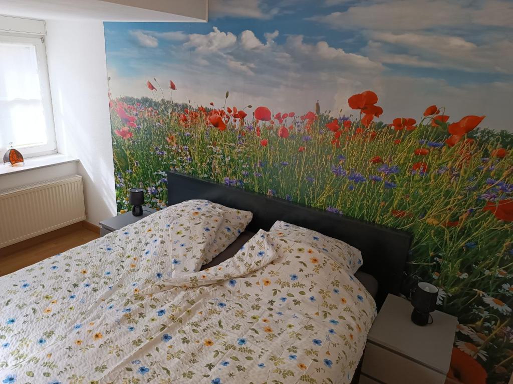 een slaapkamer met een schilderij van een bloemenveld bij Lillie 3-4 Personen - Ferienwohnungen Wagner & Gaul Falkenauel in Falkenauel