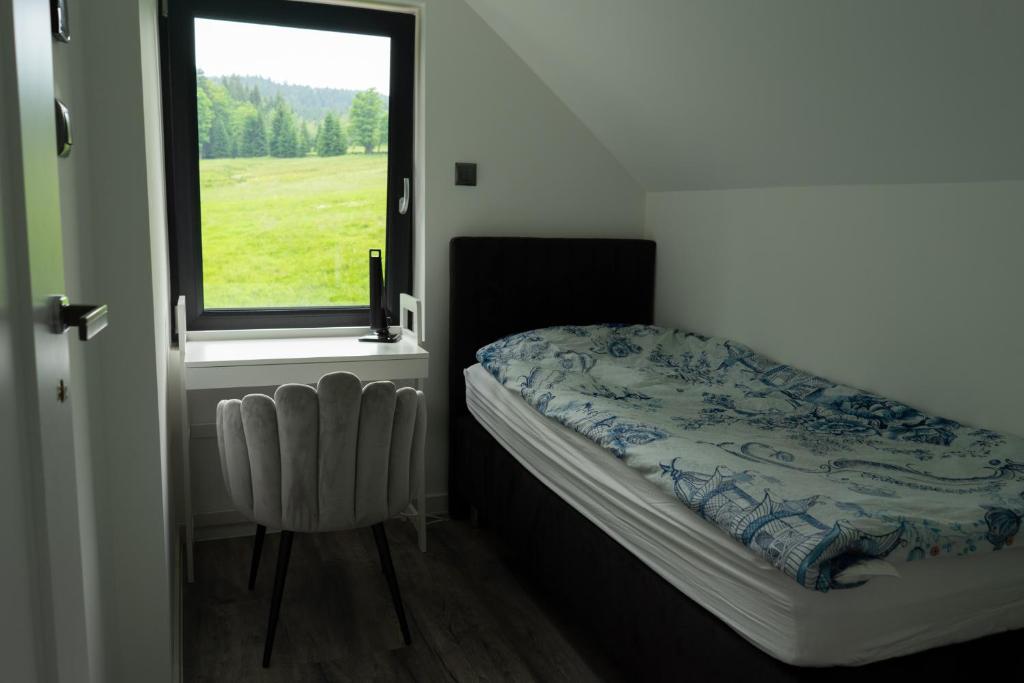 Habitación pequeña con cama y ventana en Magiczne Miejsce, en Szklarska Poręba