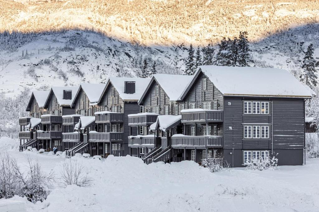 un gran edificio en la nieve con techos nevados en Tinden Apartment 310, en Kyrkjebøen