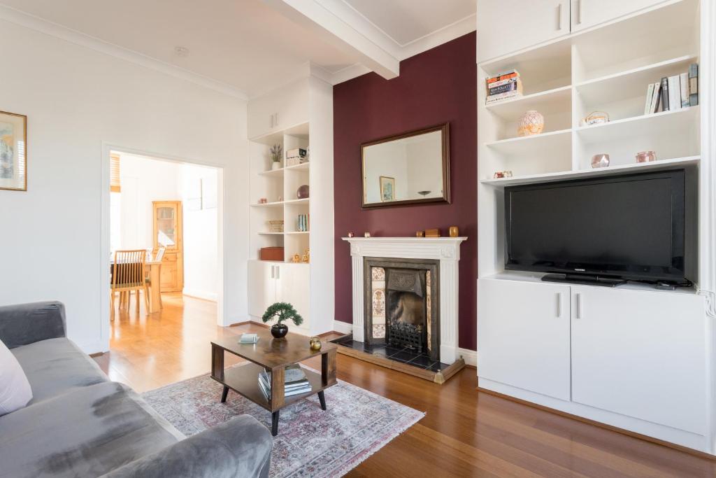 a living room with a television and a fireplace at Beautiful Home in Camden with Garden in London