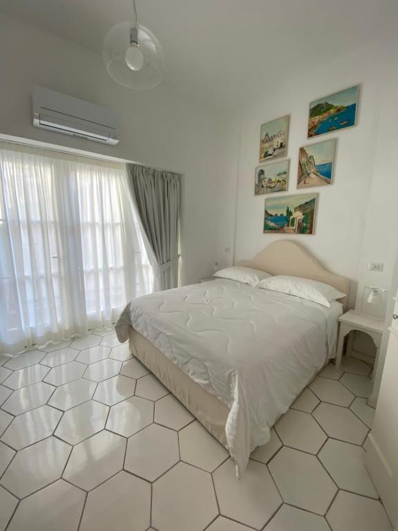 1 dormitorio con 1 cama y suelo de baldosa blanca en CASA ELISA, en Capri