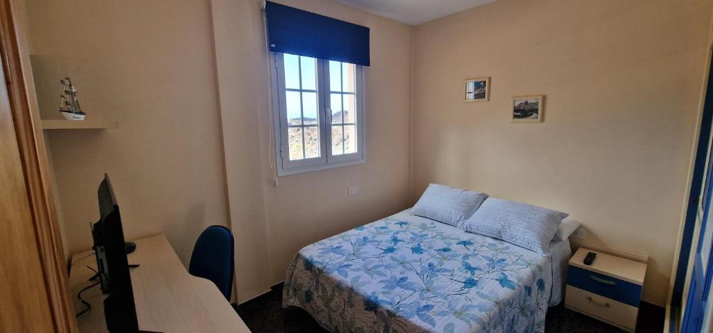 een kleine slaapkamer met een bed en een raam bij VV EL OASIS in Tamaduste
