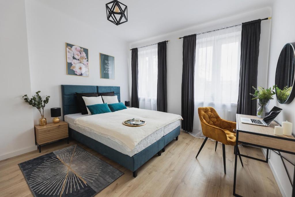 a bedroom with a king sized bed and a desk at Toka City Centrum in Szczecin