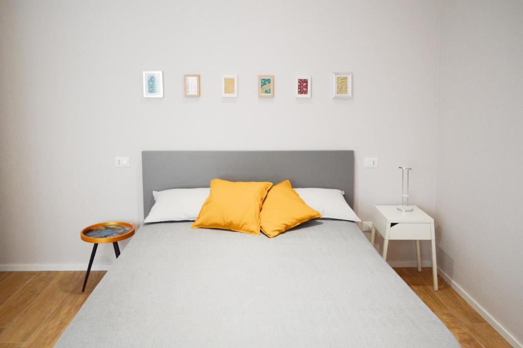 ein Schlafzimmer mit einem Bett mit zwei gelben Kissen in der Unterkunft Regina Apartment in Pescara