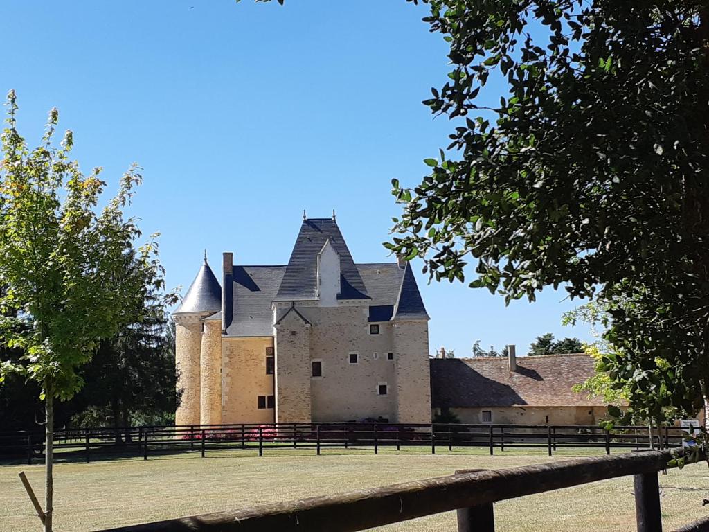 ein Schloss mit einem Zaun davor in der Unterkunft Manoir de la Beunèche - location du manoir entier in Roézé-sur-Sarthe