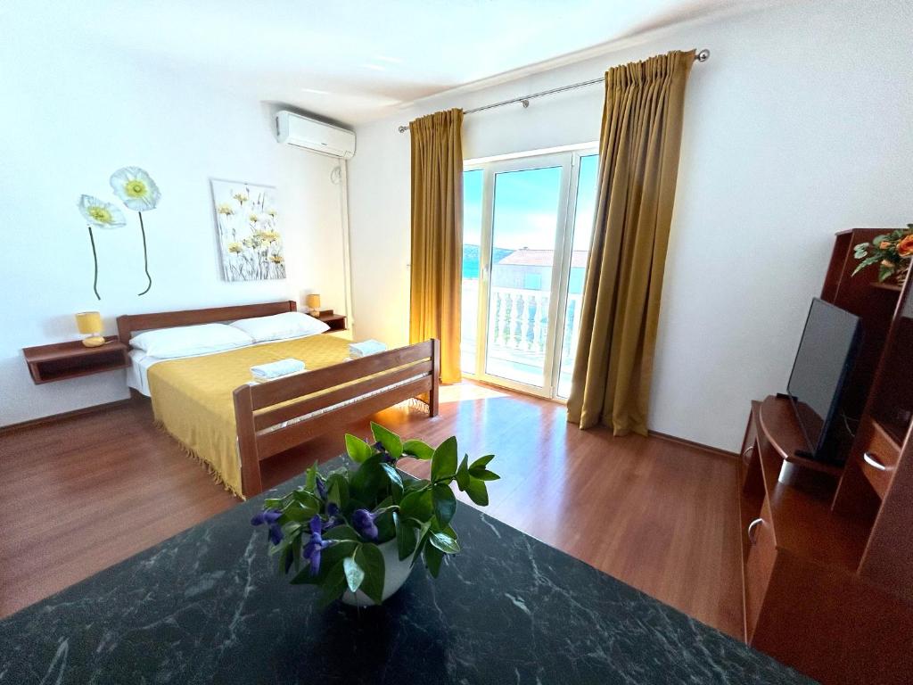 pokój hotelowy z łóżkiem i telewizorem oraz pokój w obiekcie Apartments Štokić w Rabie