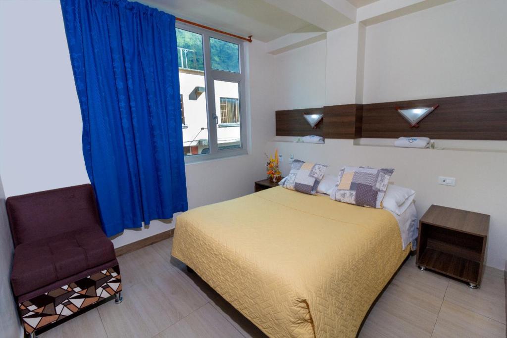 a bedroom with a bed and a chair at Hotel La Cumbre in Baños