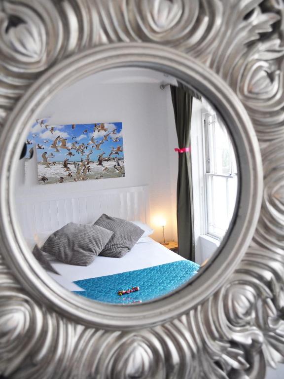 a mirror reflection of a bed in a bedroom at Motel Schmotel in Brighton & Hove