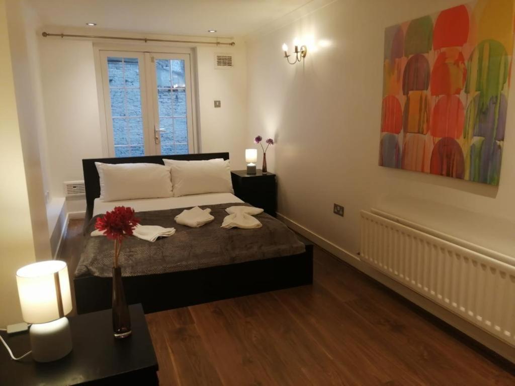 ein Schlafzimmer mit einem Bett mit zwei Handtüchern darauf in der Unterkunft Entire 2-bedroom Flat in Camden in London