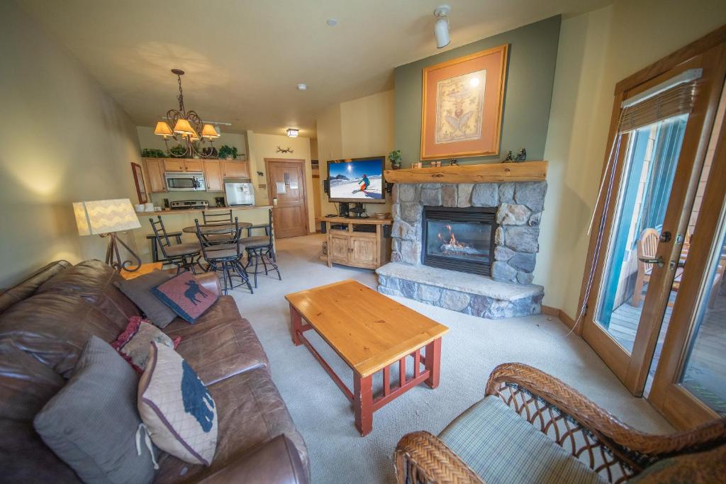 ein Wohnzimmer mit einem Sofa und einem Kamin in der Unterkunft Arapahoe Lodge 8116 in Keystone