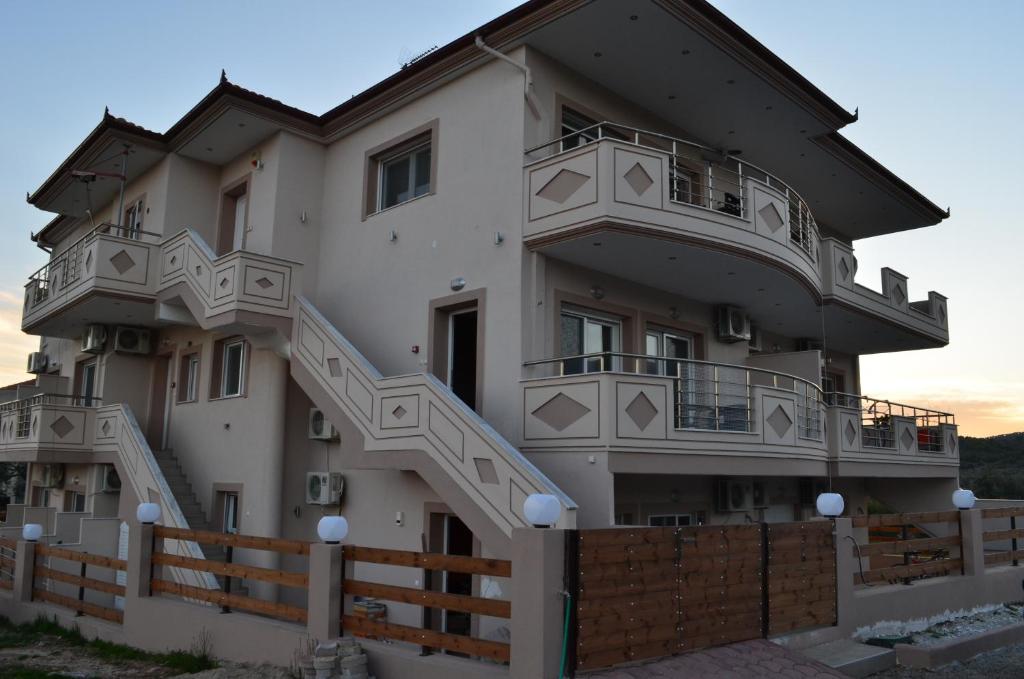 a large white building with stairs on it at Thassos Grand Villas Apartments & Studios in Limenaria